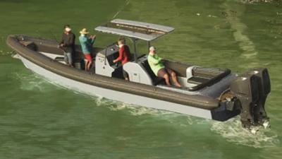 Un Dingus bleu marine sur l'eau dans GTA 6, avec des personnes à bord.