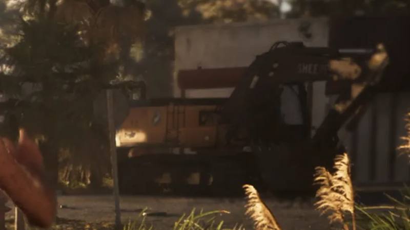 Une pelleteuse Jack Sheepe jaune et noire devant un bâtiment Schlott Construction.