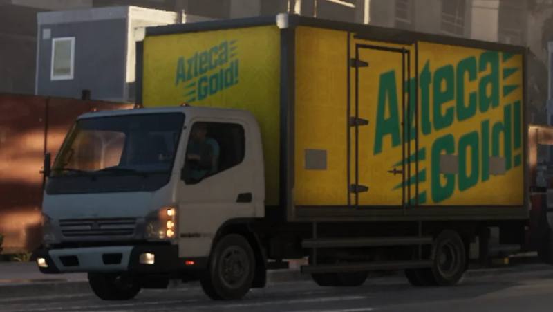 Un Maibatsu Mule, un camion commercial orange avec une livrée "Azteca Gold!", dans Grand Theft Auto VI.