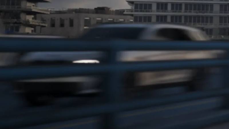 Une Übermacht Rebla GTS de couleur foncée circulant dans les rues de Vice City.