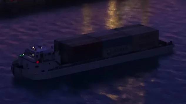 Une barge industrielle de couleur sombre navigant dans les eaux de Vice City, avec des structures portuaires en arrière-plan.