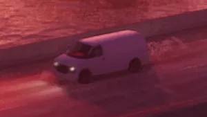 Un fourgon Vapid Speedo blanc stationné dans une rue de Vice City, typique des véhicules utilitaires
